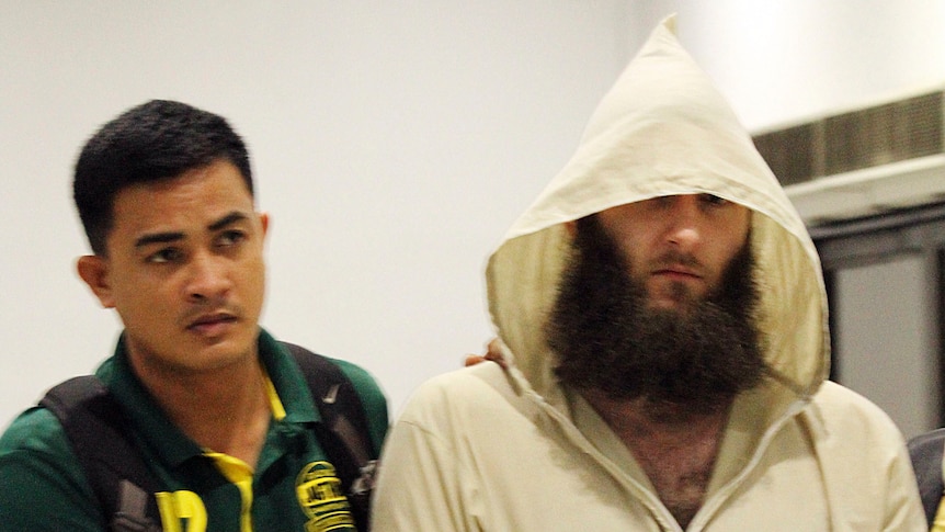 Musa Cerantonio is escorted by police intelligence upon arrival at the domestic airport in Manila, Philippines