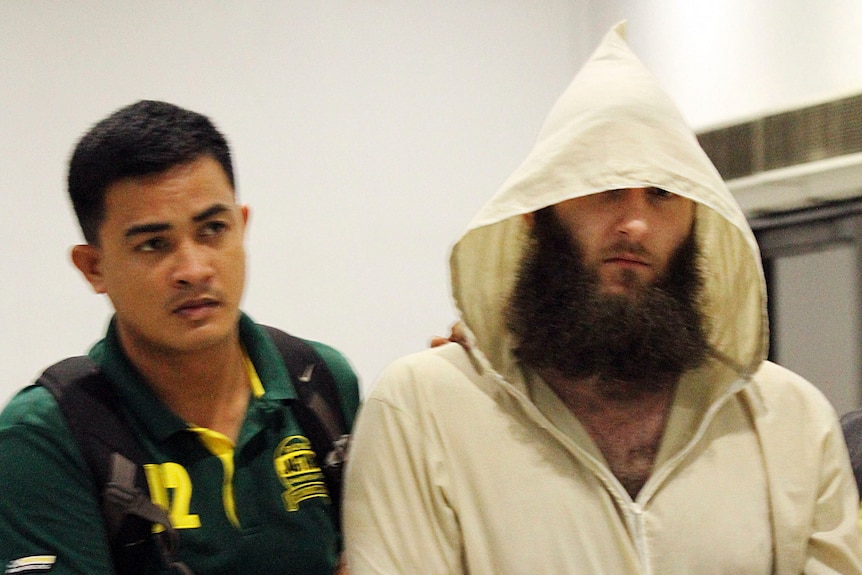 Musa Cerantonio is escorted by police intelligence upon arrival at the domestic airport in Manila, Philippines