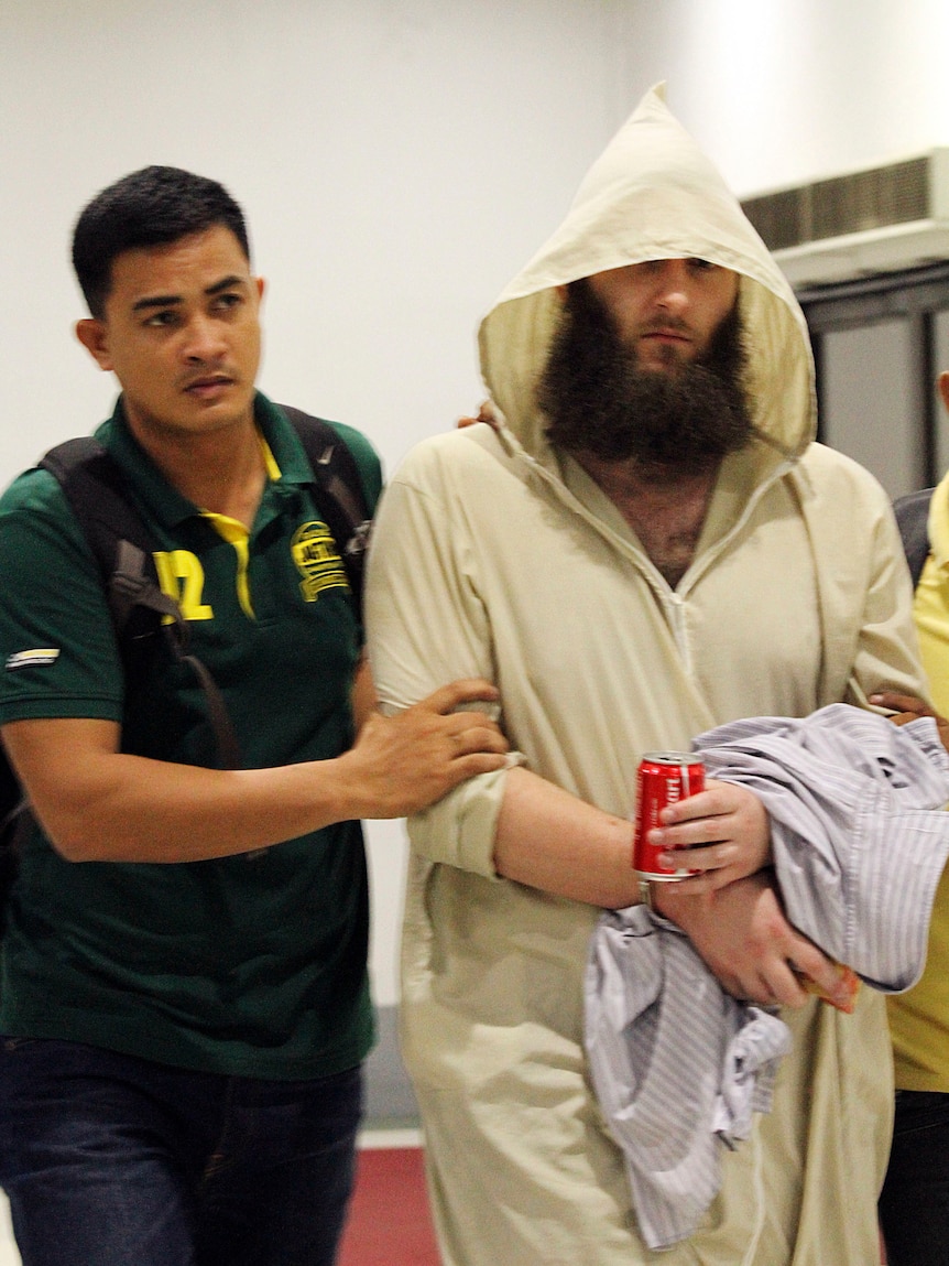 Musa Cerantonio is escorted by police intelligence upon arrival at the domestic airport in Manila, Philippines