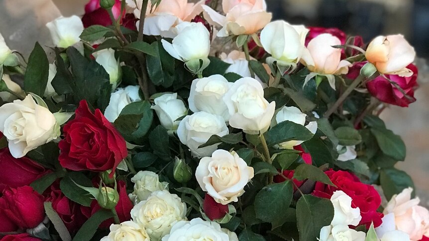 yellow, cream, red and orange roses in a bouquet