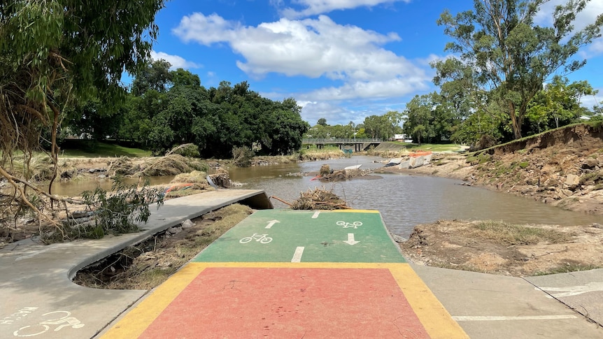 A damaged bikeway ending in a flooded debris field