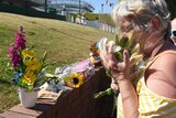 People lay flowers down at Dreamworld theme park