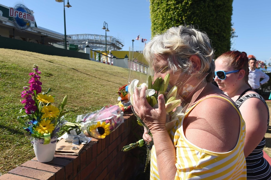 People lay flowers down at Dreamworld theme park