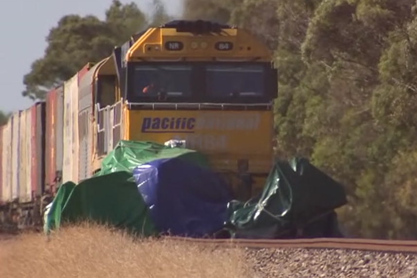 A freight train crashed into a car covered in a tarpauline