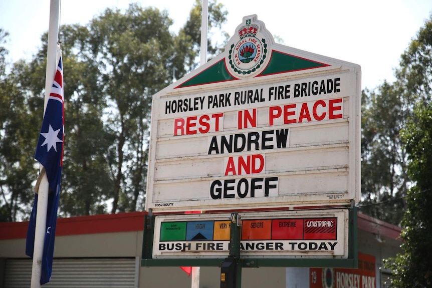 A sign says 'Rest in Peace Andrew and Geoff'