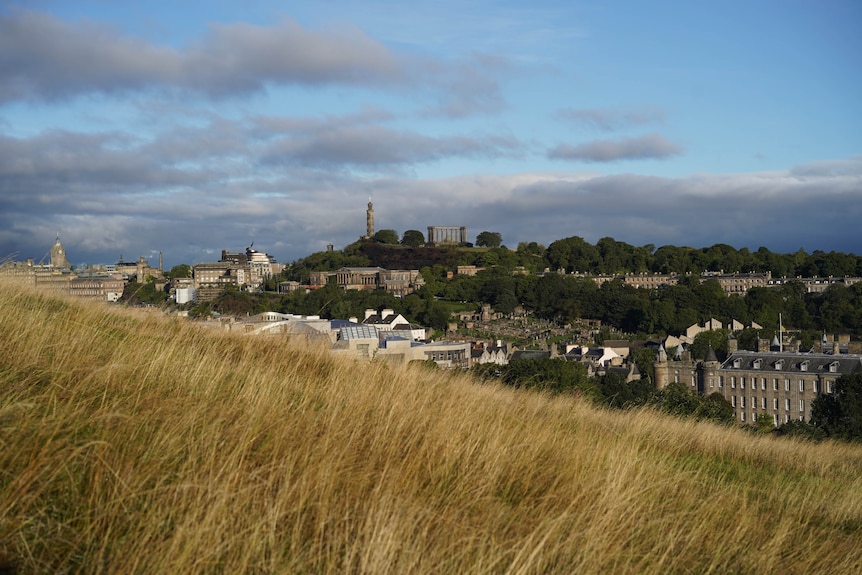 A grassy hill overlooks the city of Edinburgh