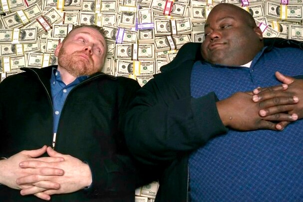 A scene from Breaking Bad where two men lie on a pile of money.