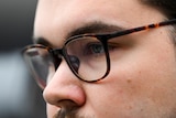 A close up of a man's glasses. 