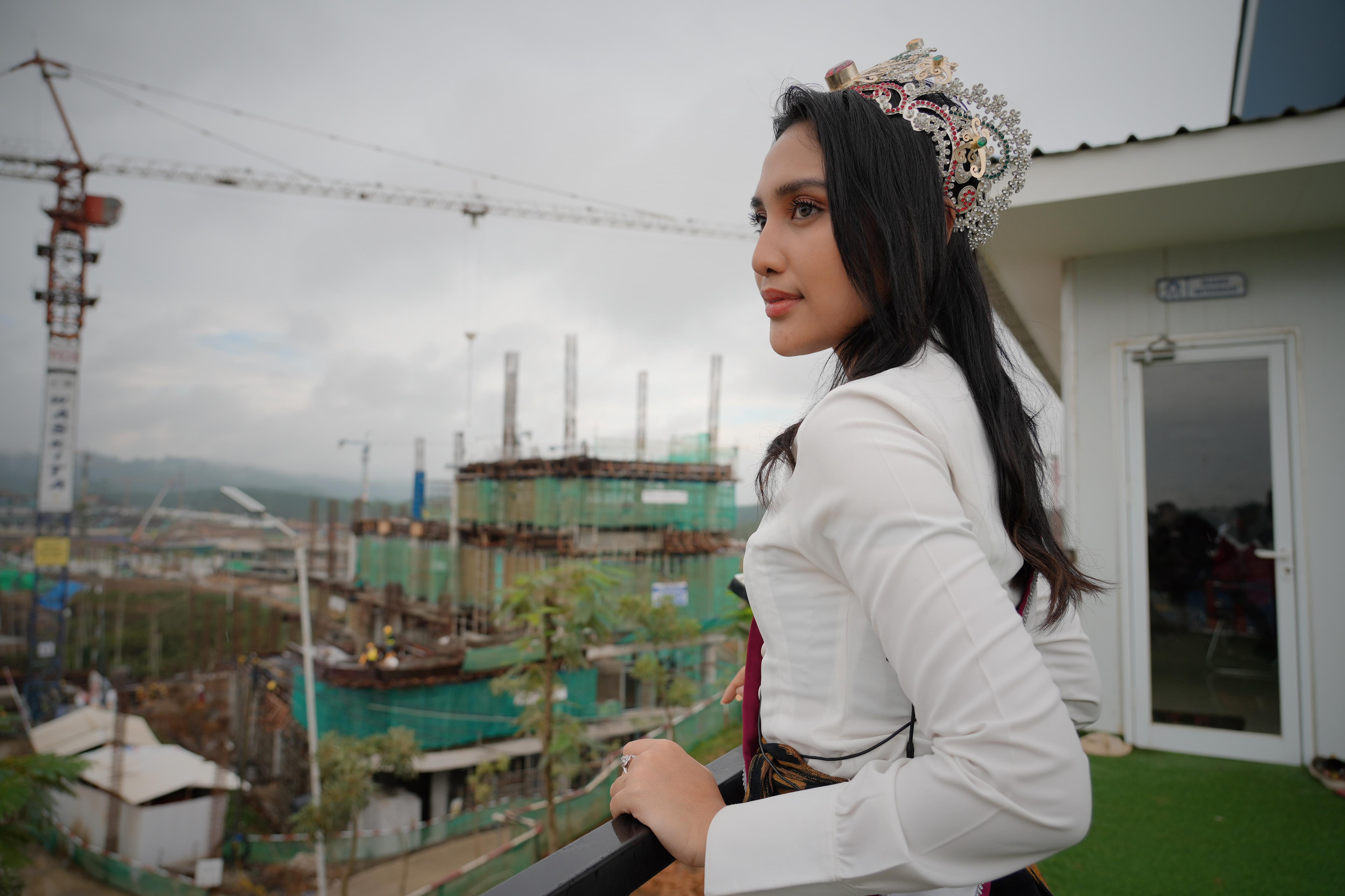 A woman looks out over a construction site.