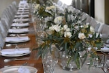 A wedding table complete with plates and flowers.