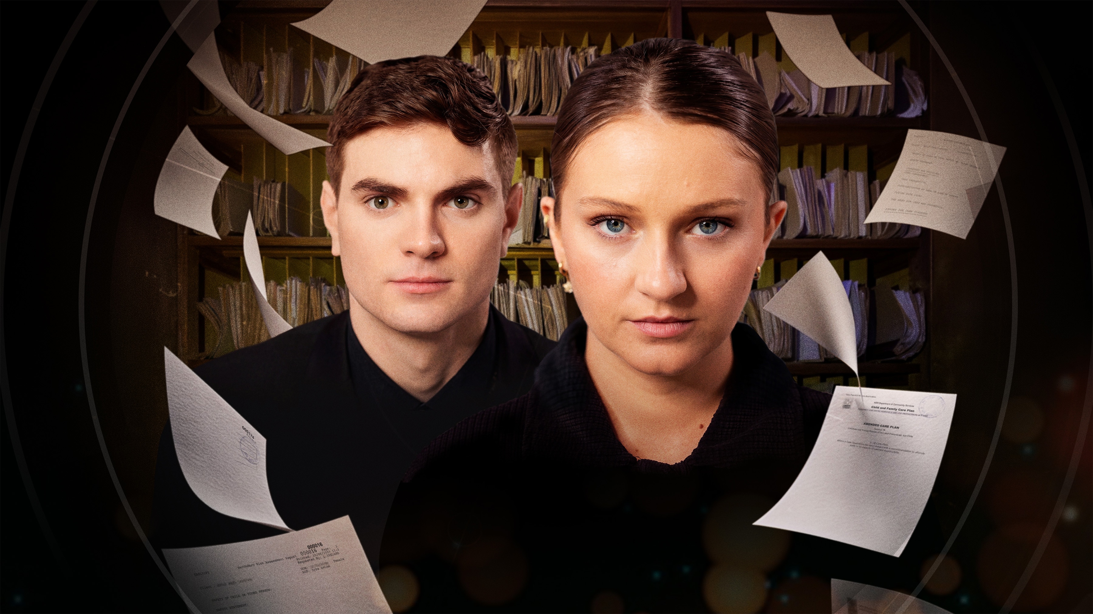 Head and shoulders shot of young man and woman looking into camera with paper flying around them in front of a bookshelf