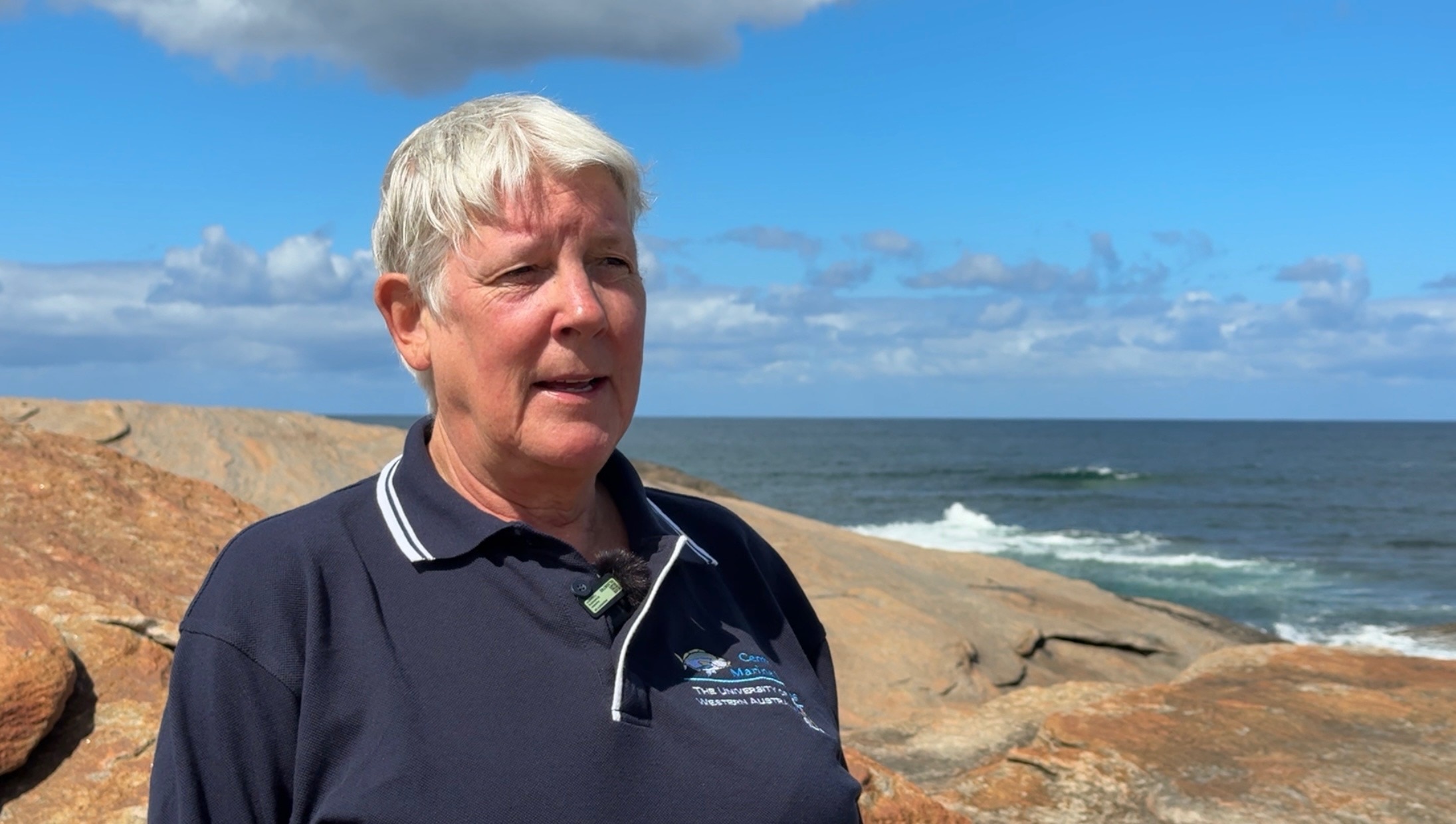 Foto média de uma mulher em frente a algumas pedras.