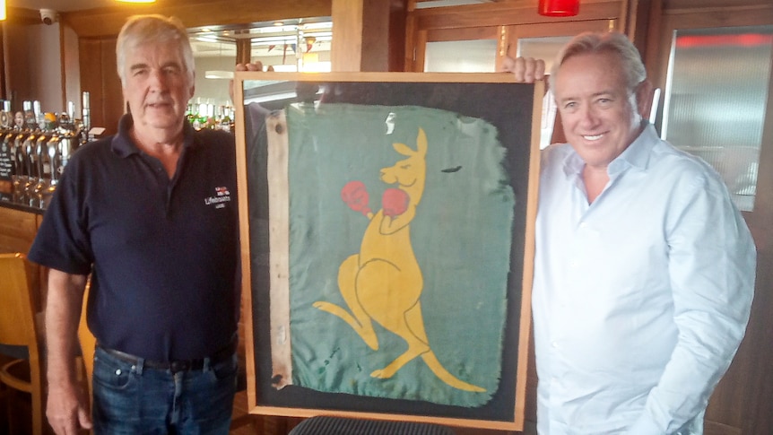 Two men with old flag in frame.