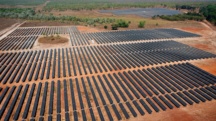 Aerial view of a solar farm surrounded by bushland.