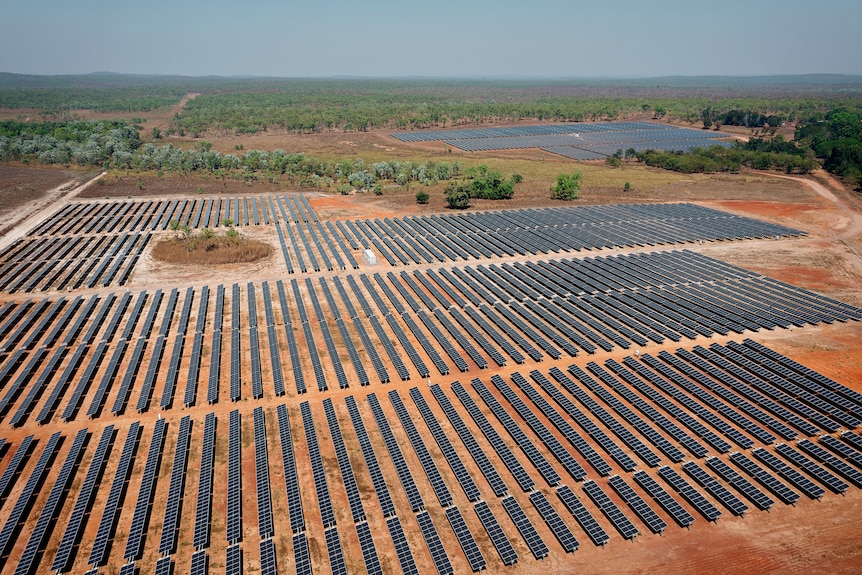 Aerial view of a solar farm surrounded by bushland.
