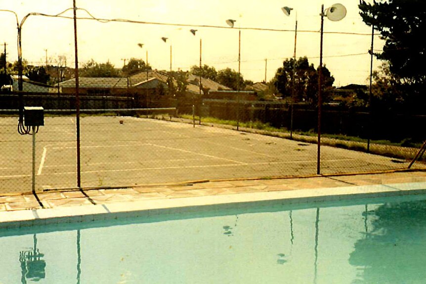 An old photo of a swimming pool and a tennis court