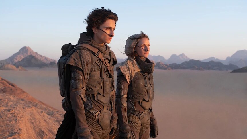 A man and a woman standing on top of a mountain in a new movie called Dune.