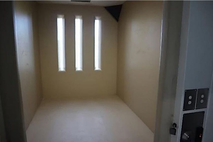 A small bare room with narrow rectangle windows on one wall