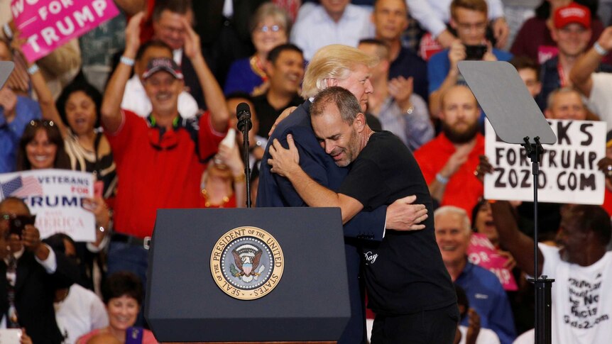 Donald Trump hugs a supporter at a rally