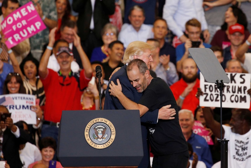 Donald Trump hugs a supporter at a rally