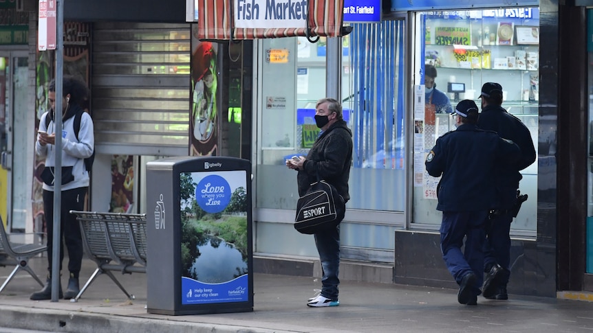 Two police officer walk through a shutdown shopping district in Fairfield, in Sydney's south west. 