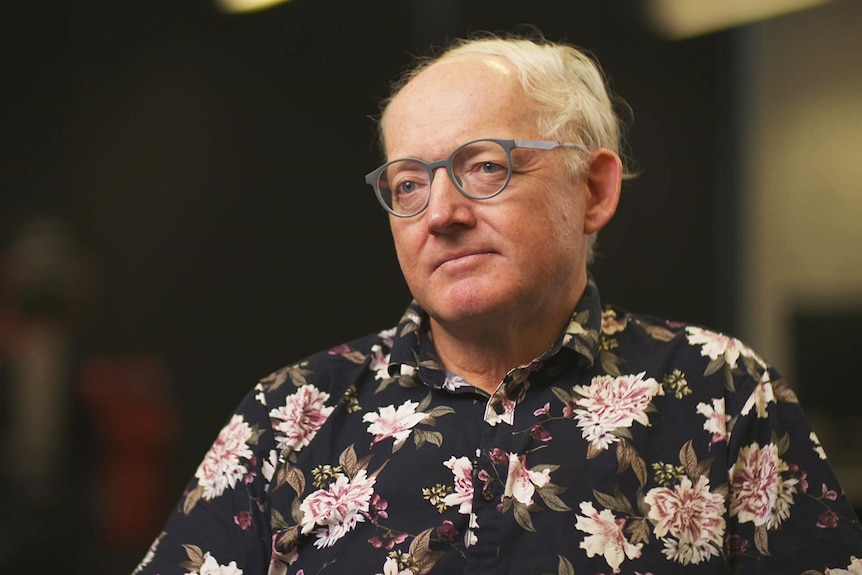 A man wearing a floral collared shirt.