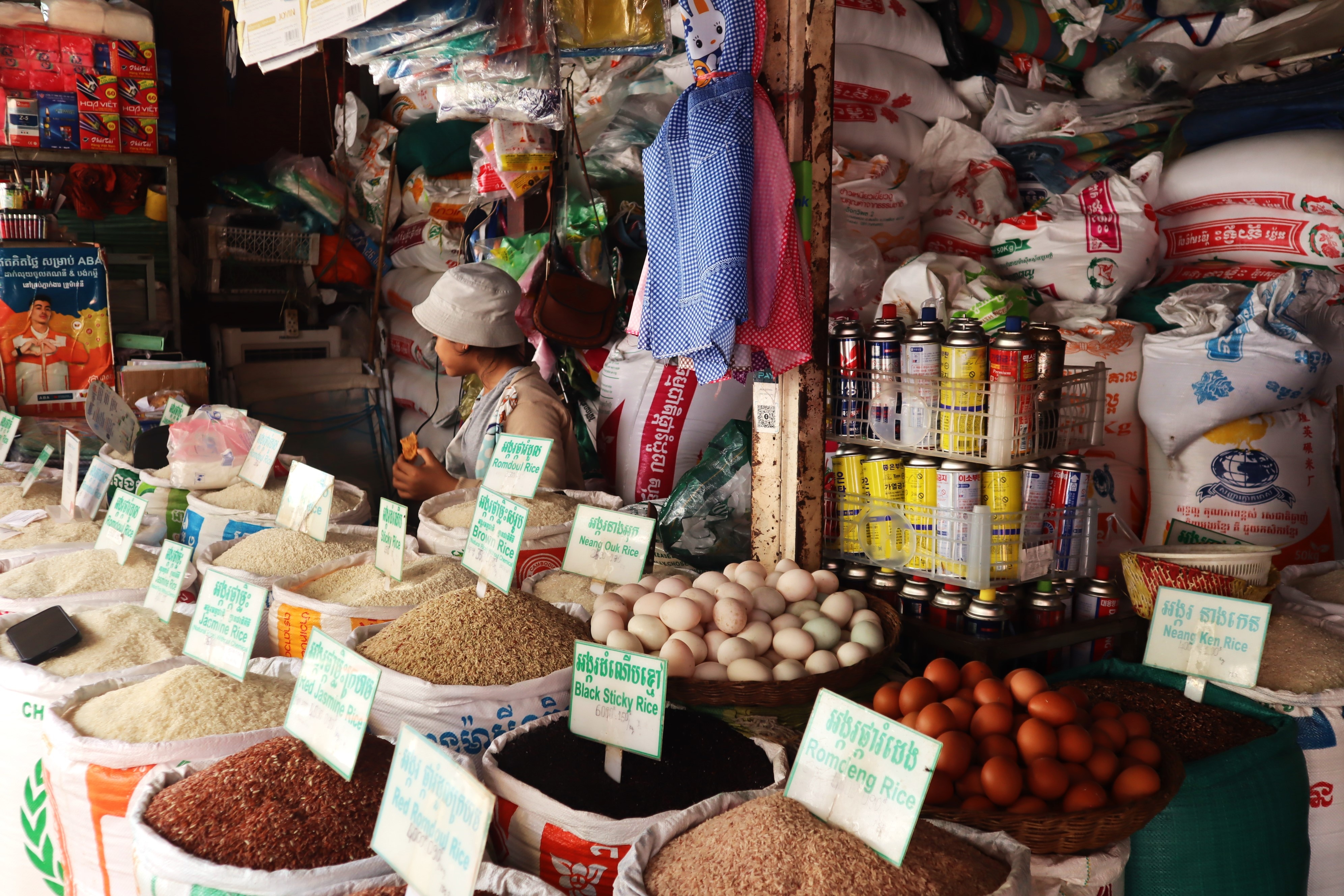 Woman sells grains of a rice at food stall in Cambodia.