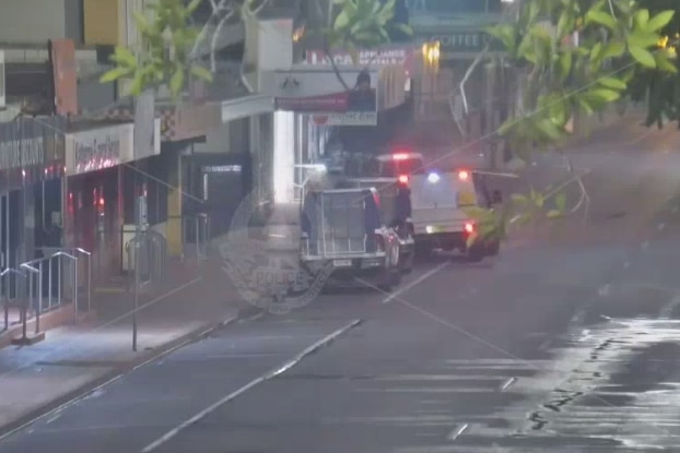 A screenshot of a white car running into a police car on a street. 