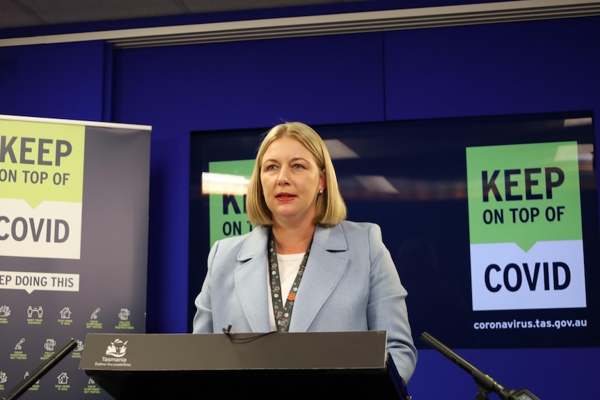 Kathrine Morgan-Wicks, a woman with shoulder-length blonde hair, stands at a lectern