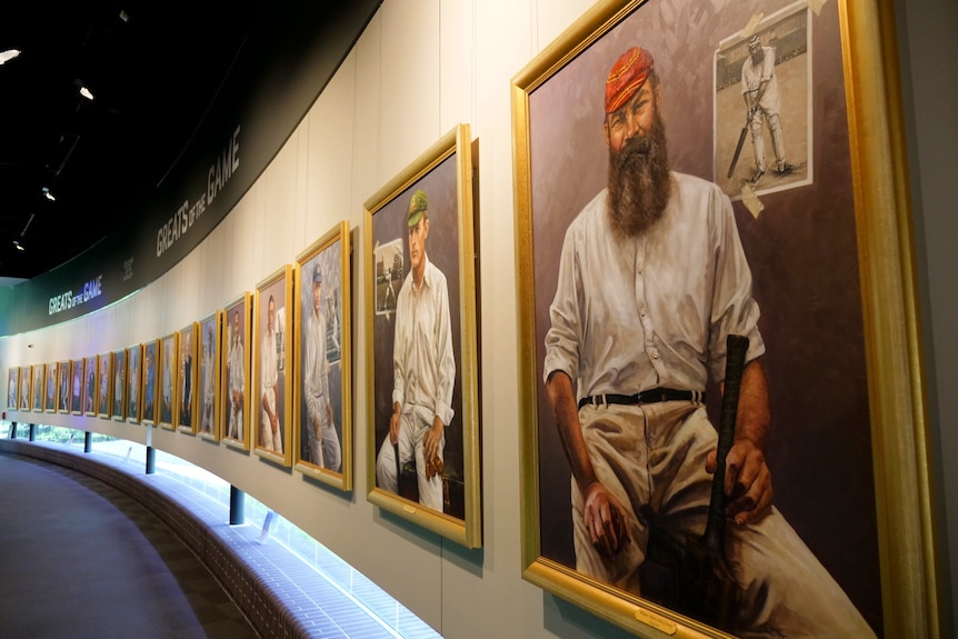 A wall lined with painted portraits of cricket players