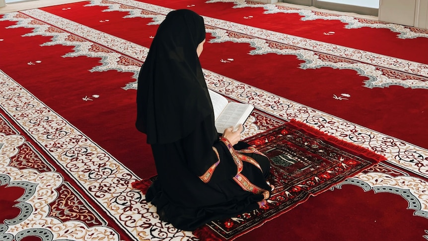 A woman on a prayer mat in a mosque