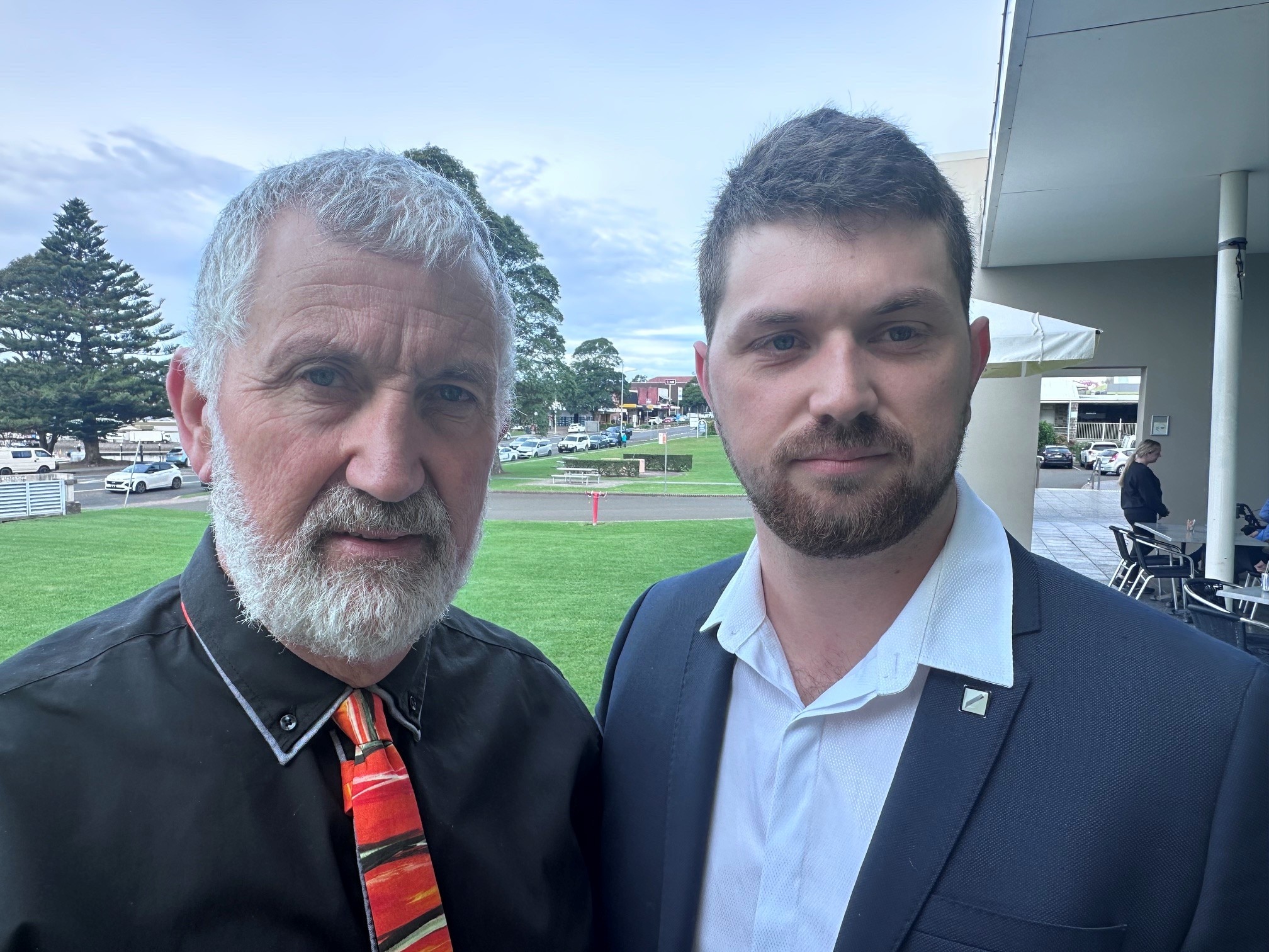 Two men standing together out side