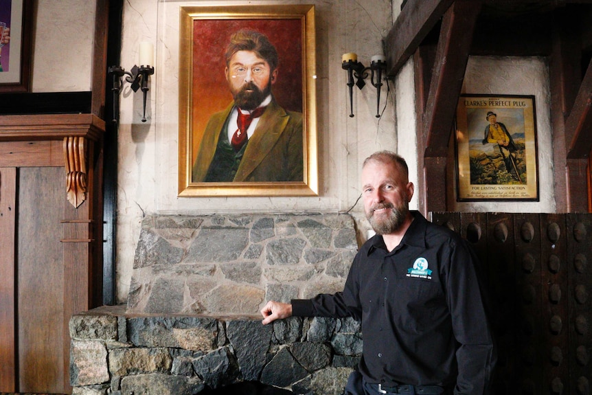 Pub-owner Peter Barcley stands beside a portrait of King O'Malley.