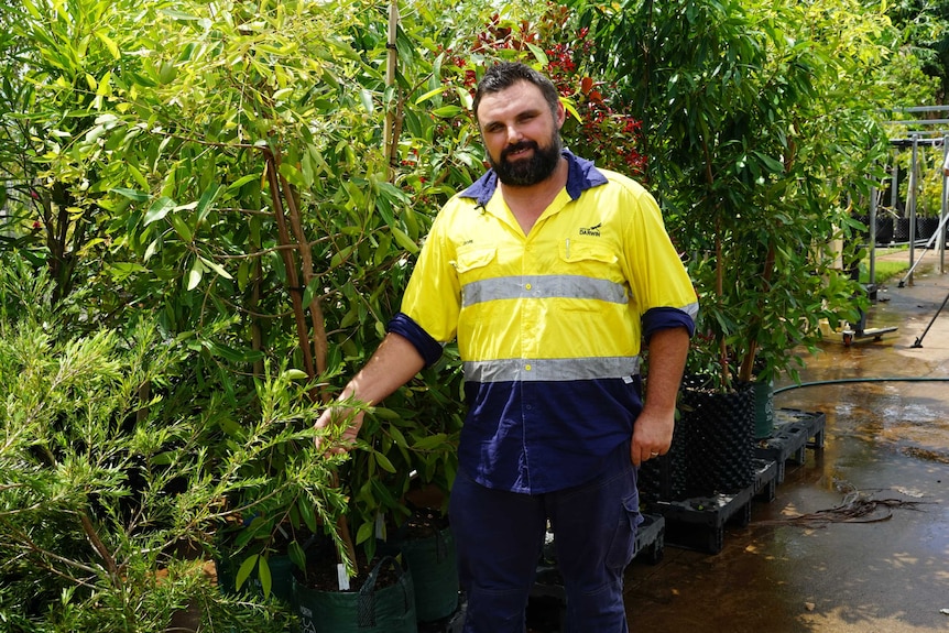 A man stands in a nursery.