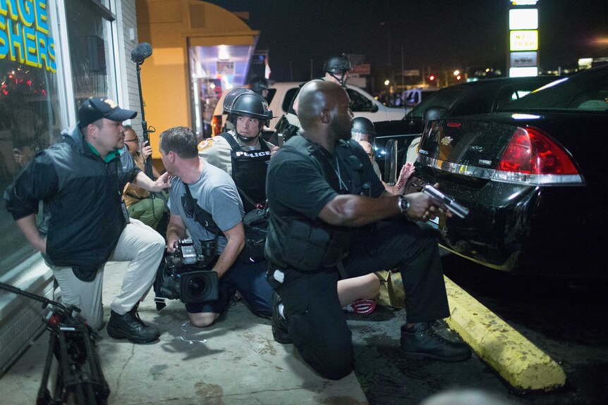 Police take cover as gunfire erupts in Ferguson