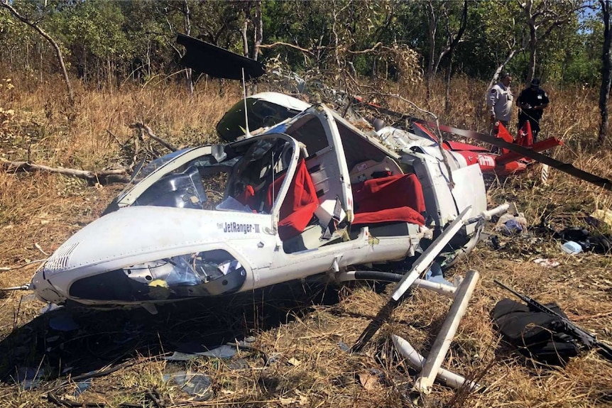 Helicopter wreckage in remote terrain.