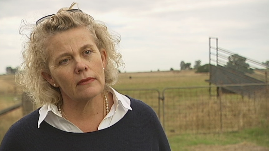 A woman on a farm, looking concerned