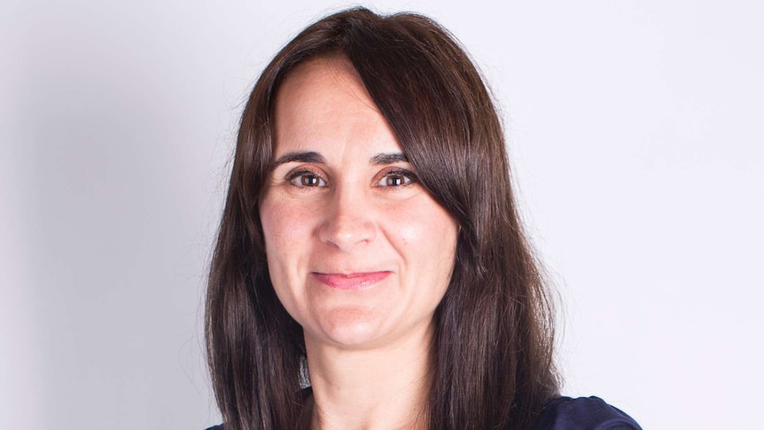 Headshot of a woman with long brown hair and blue shirt.