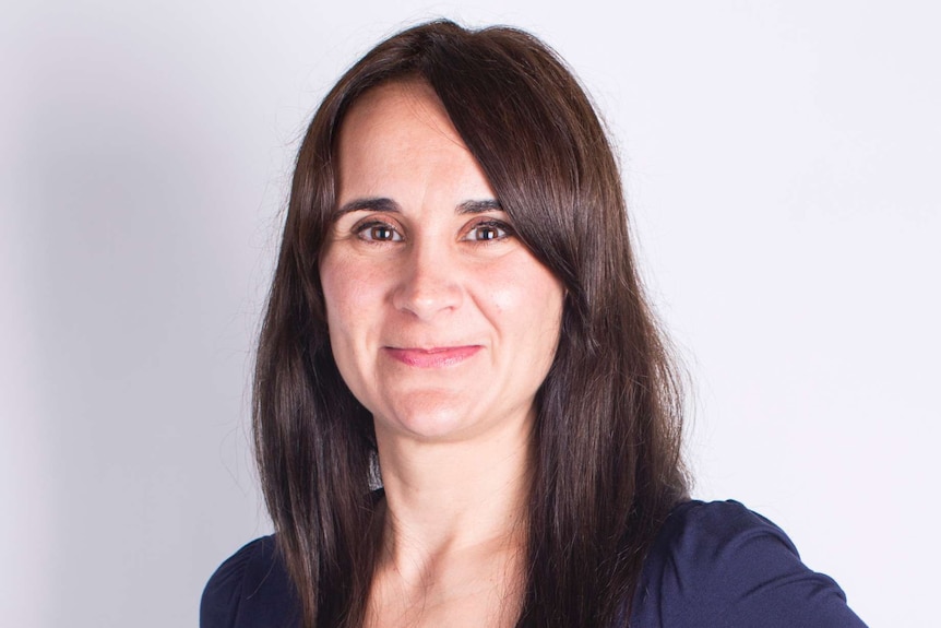 Headshot of a woman with long brown hair and blue shirt.