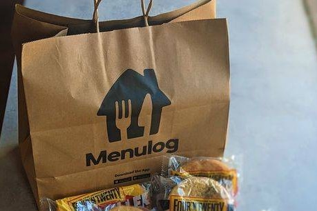 A Menulog food delivery bag with pies in plastic.