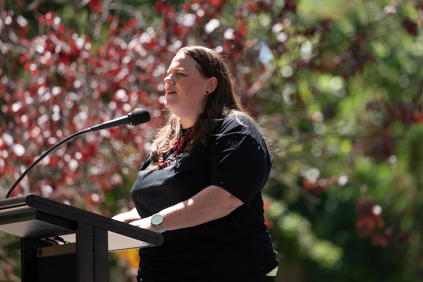 una mujer hablando al aire libre en un podio