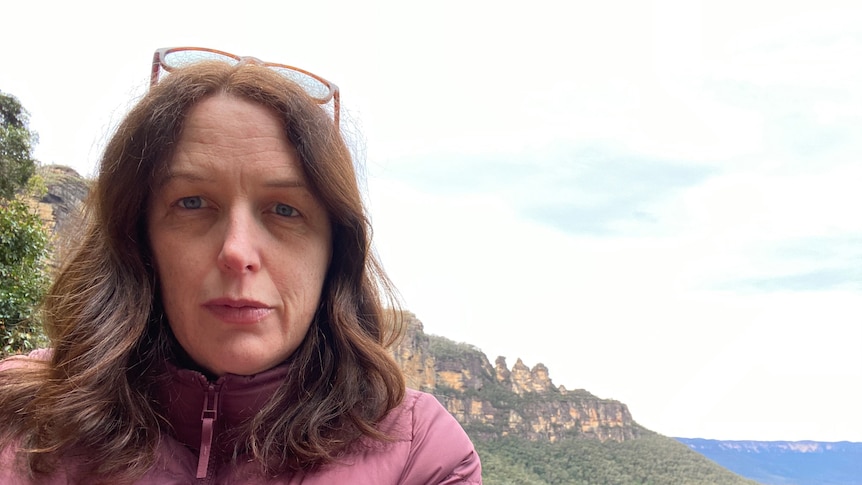 The writer Kate Dorrell poses for a selfie in Katoomba, with rugged mountains behind her