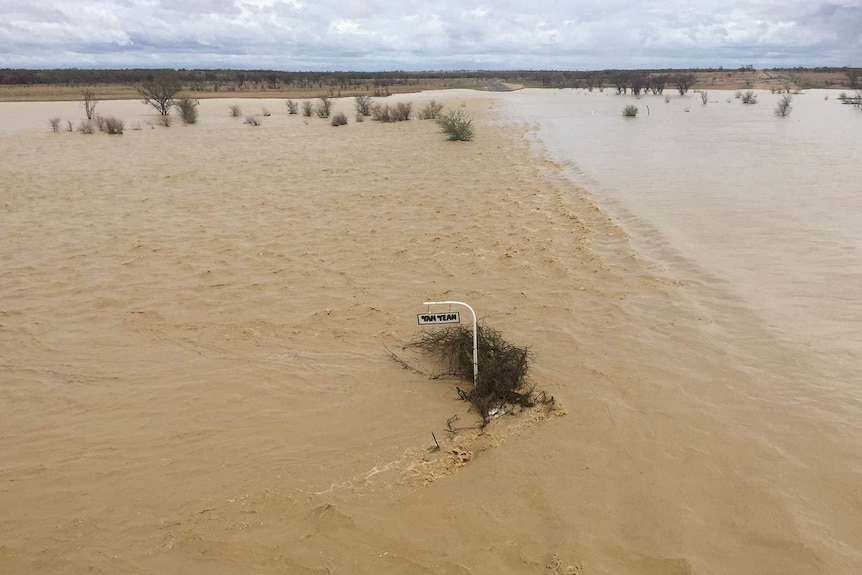 Floodwaters cover sign and driveway at Yan Yean station turn-off at Richmond in north-west Queensland on February 1, 2019.