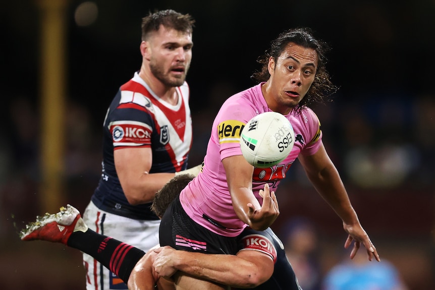 A Penrith Panthers NRL player gets a pass away against the Sydney Roosters.