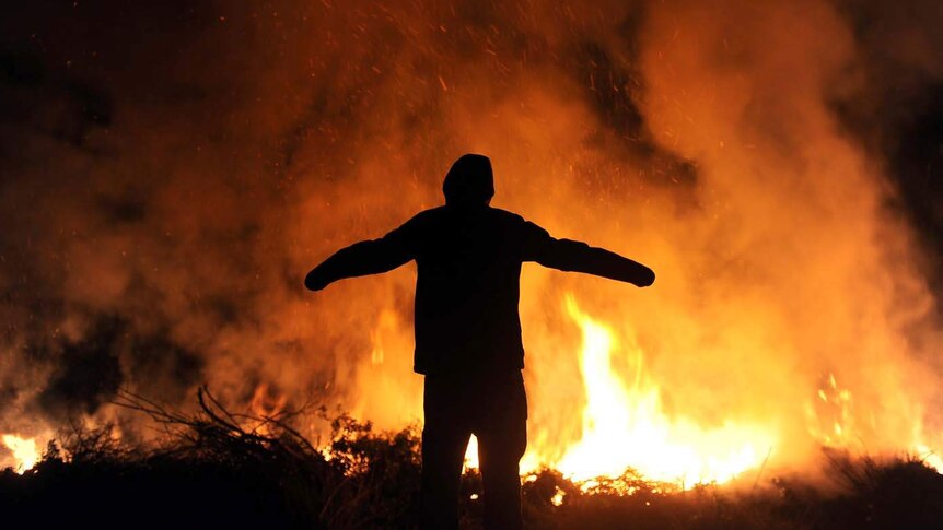 A man stands next to an Easter bonfire in Germany