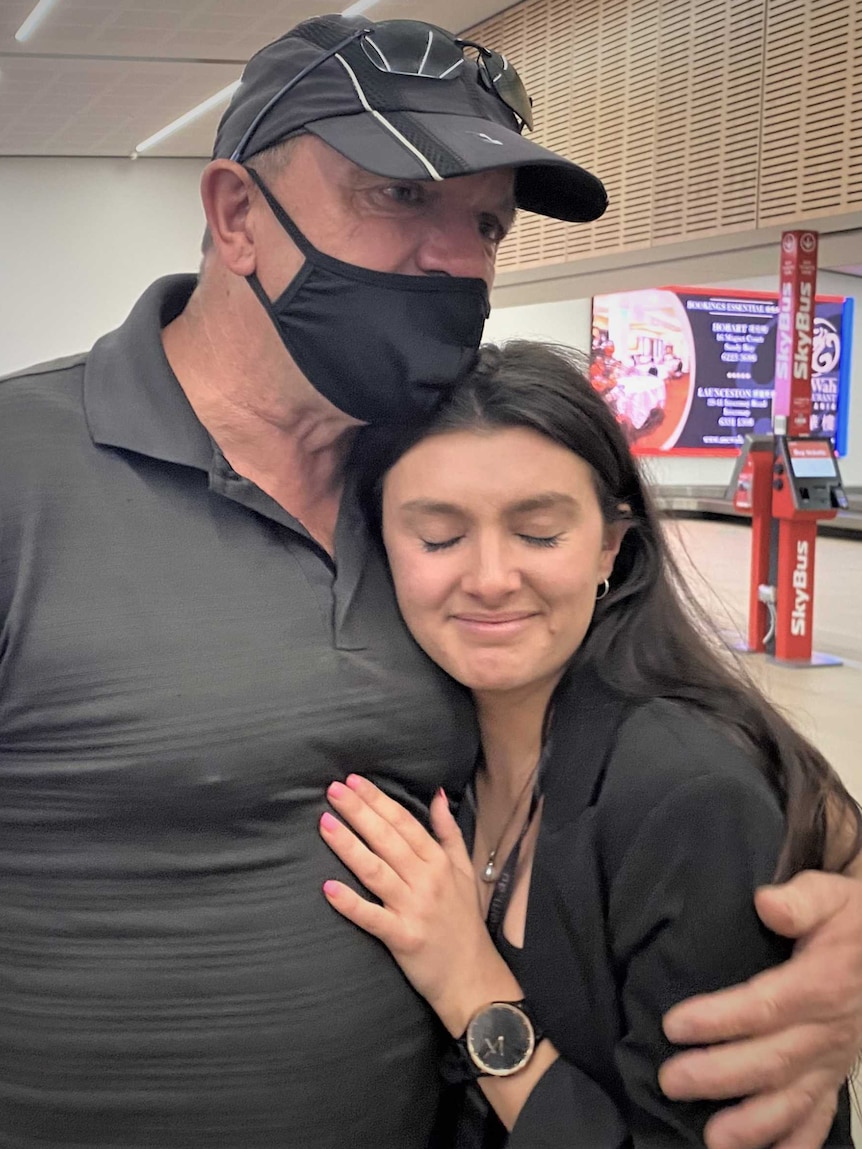 Tara Mrhar and father Marly Mhrar embrace at an airport.