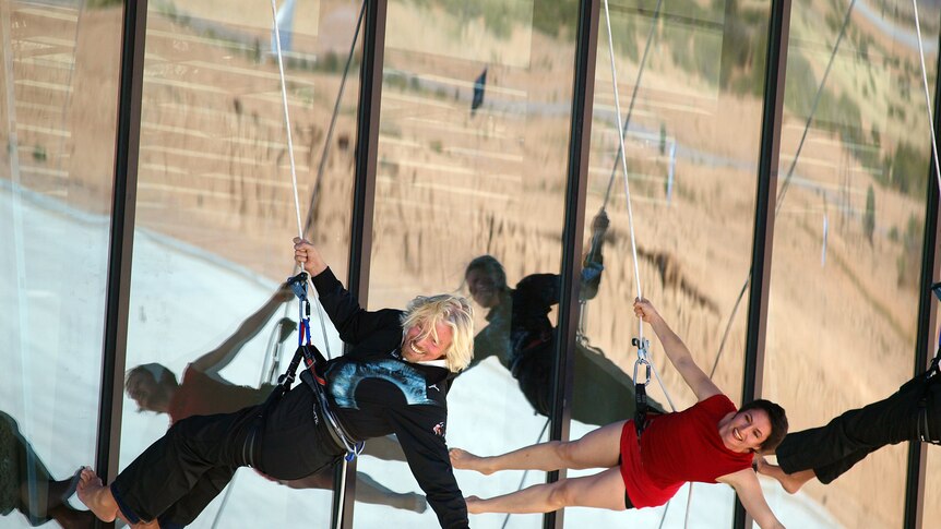 Virgin CEO Richard Branson abseils down the side of the newly dedicated New Mexico spaceport.