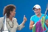 Evonne Goolagong Cawley holding a tennis trophy and giving thumbs up to a laughing Ash Barty.
