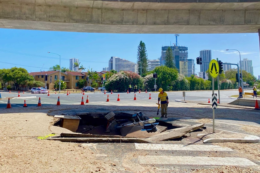 Sink hole opens on busy intersection with traffic lights fallen inside.