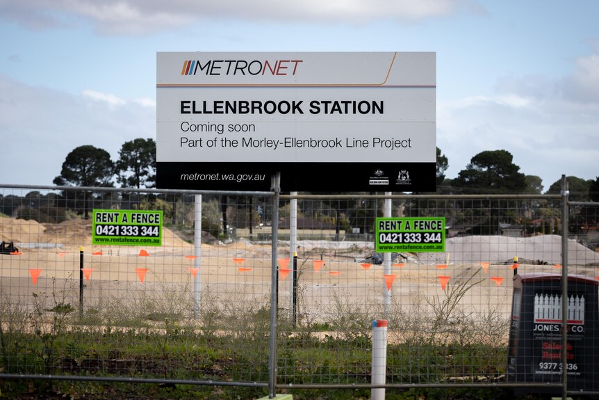 A large sign with Ellenbrook Station on it in a fenced off construction site.